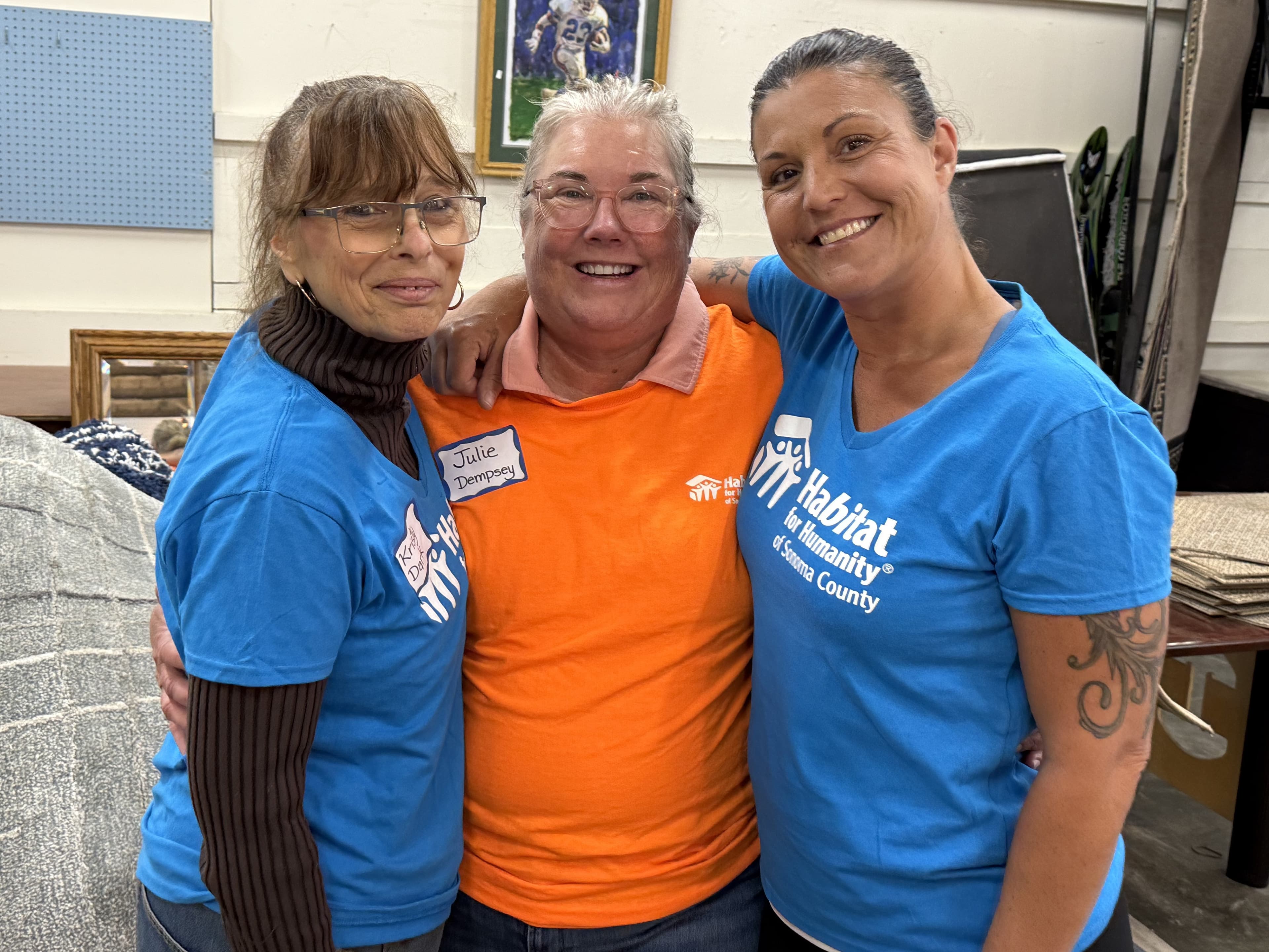 Three NORBAR volunteers in Habitat for Humanity of Sonoma County shirts at the ReStore.