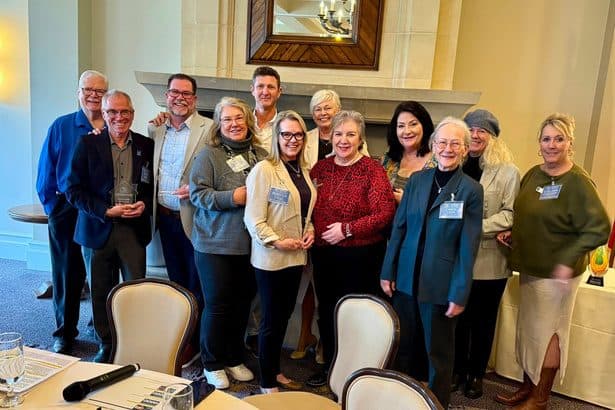 A group of NORBAR board and committee members posing together at the Annual Meeting, one holding a glass award.